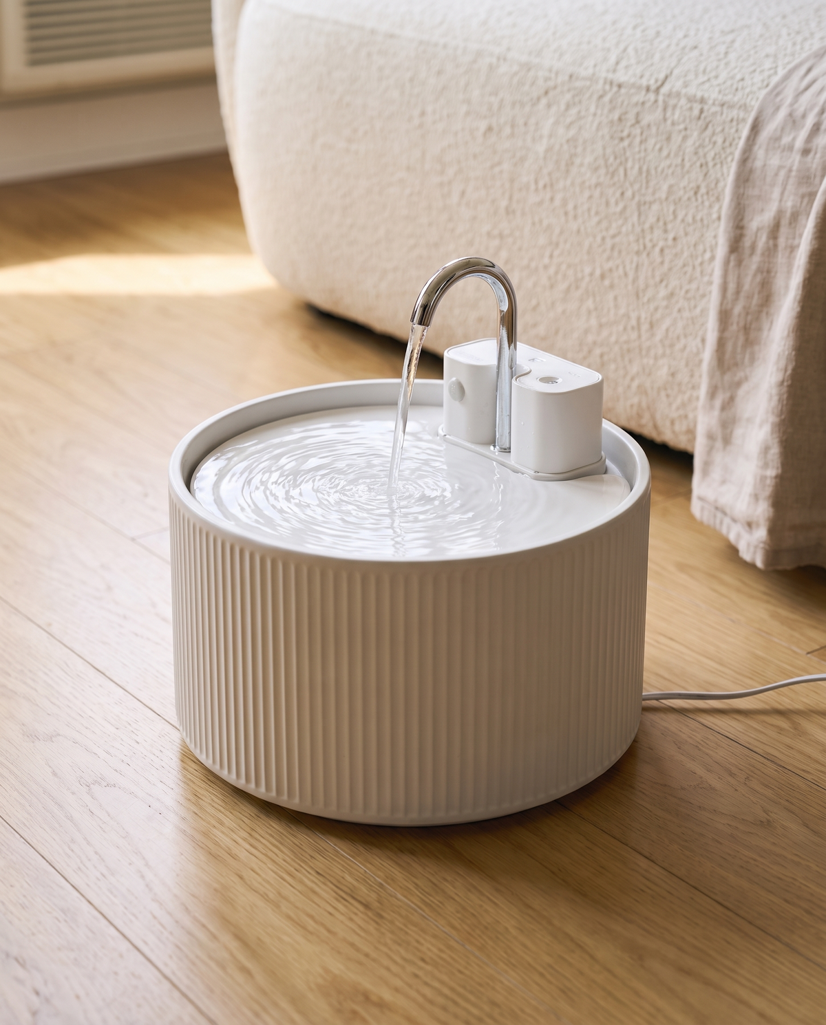 Close-up of Ondine's ribbed ceramic texture and chrome gooseneck faucet, showing the craftsmanship of the fountain